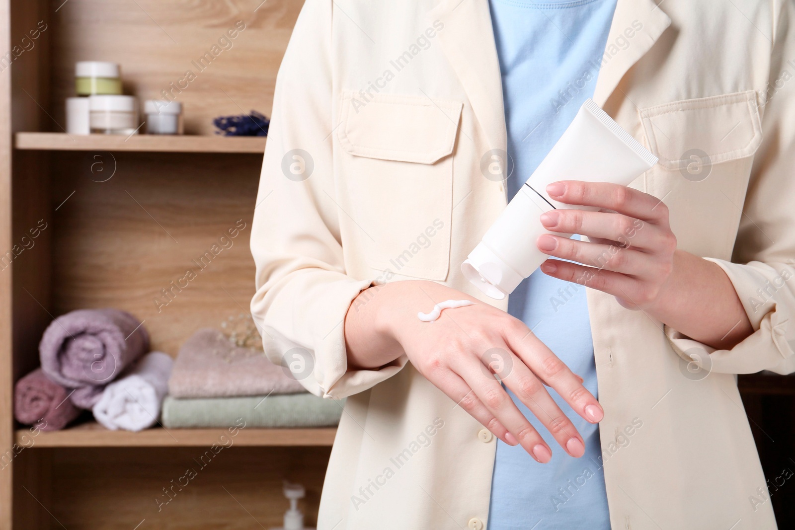 Photo of Woman applying hand cream at home, closeup