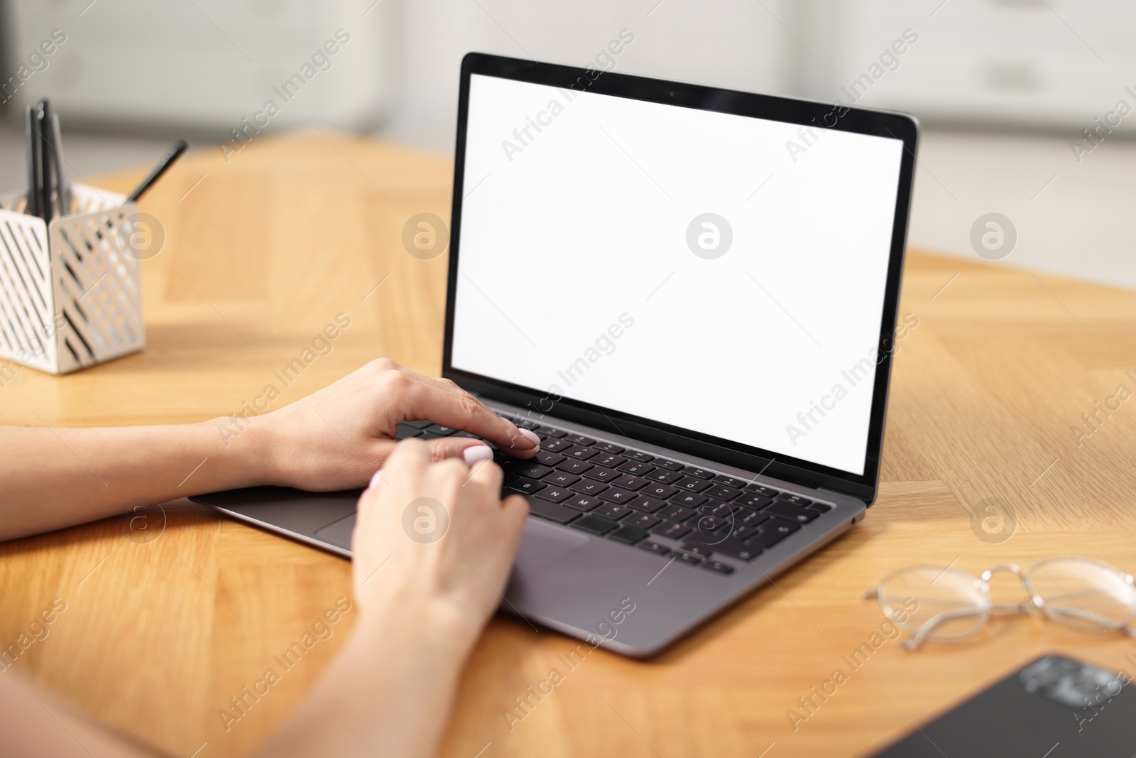 Photo of Young woman watching webinar at table indoors, closeup