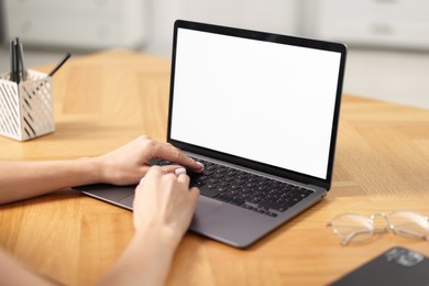 Young woman watching webinar at table indoors, closeup