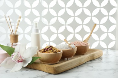 Photo of Beautiful composition with different spa products and orchid on white marble table