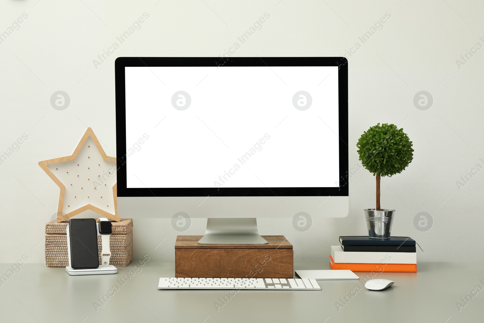 Photo of Modern workplace with computer, charging devices and decor elements. Interior design