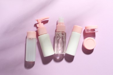 Photo of Cosmetic travel kit on violet background, top view