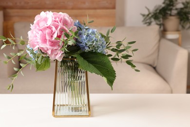 Beautiful hortensia flowers in vase on white table indoors. Space for text