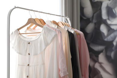 Rack with stylish women's clothes indoors. Interior design