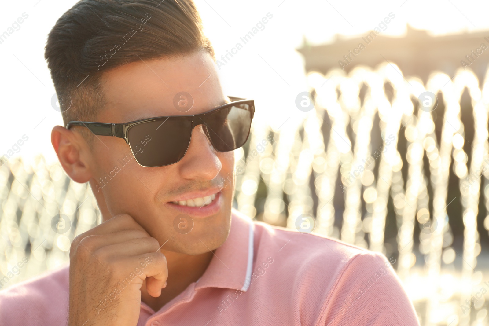 Photo of Handsome man wearing stylish sunglasses on city street