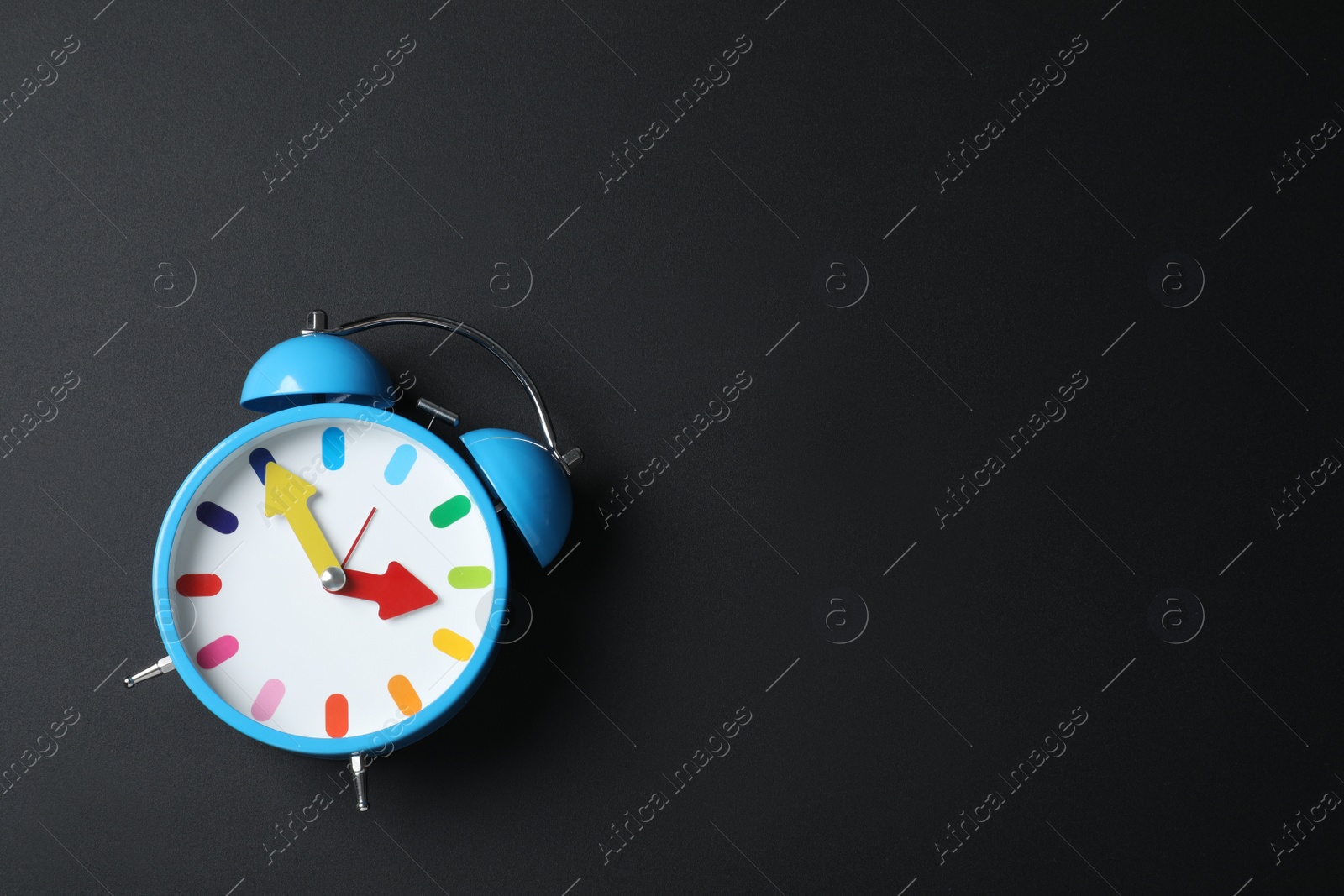 Photo of Alarm clock and space for text on black background, top view. School time