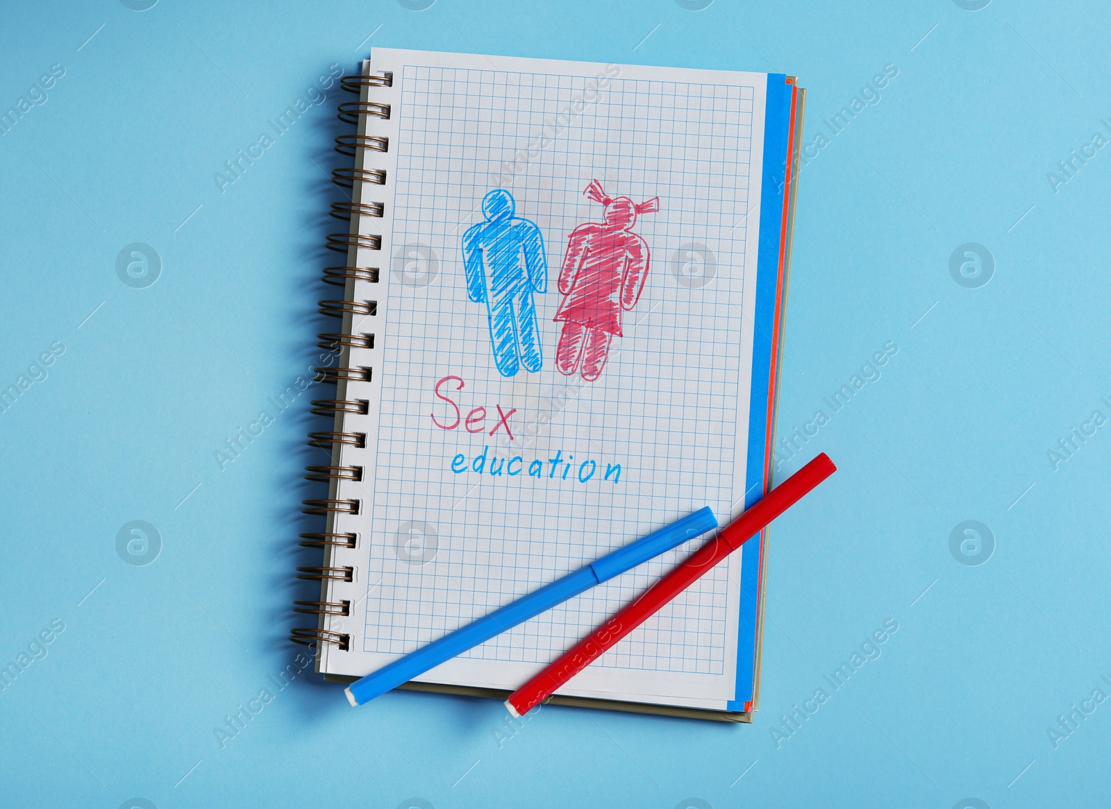 Photo of Notebook with phrase "SEX EDUCATION" on blue background, top view