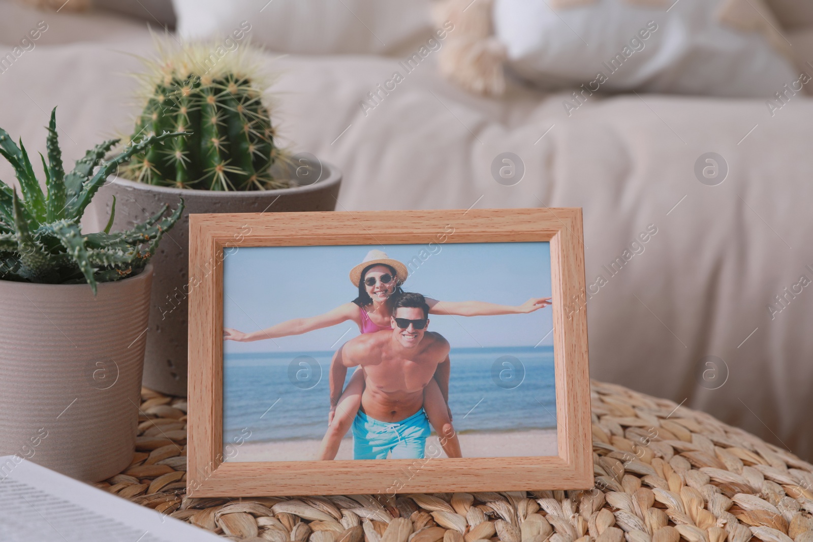 Photo of Framed photo of happy couple on wicker table in living room