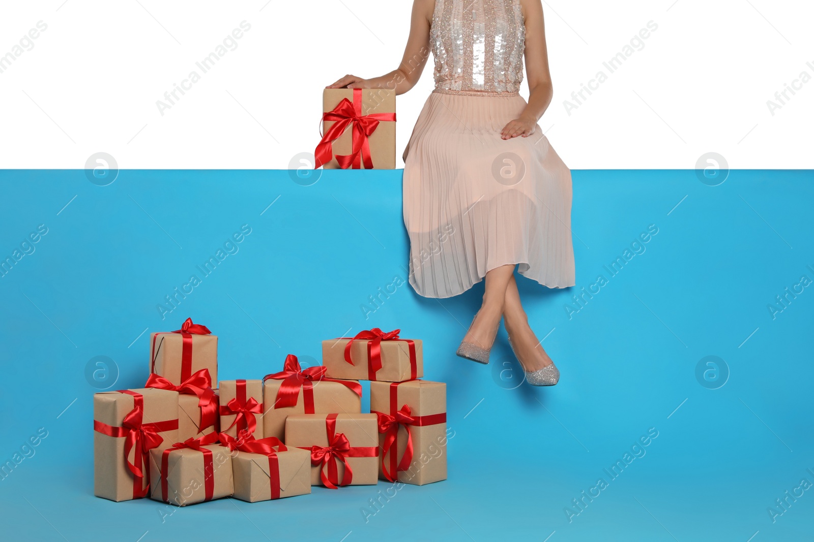 Photo of Woman and gift boxes on light blue background, closeup. Black Friday