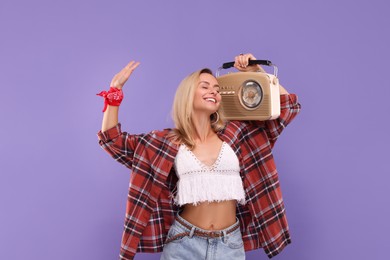 Photo of Happy hippie woman with retro radio receiver on purple background