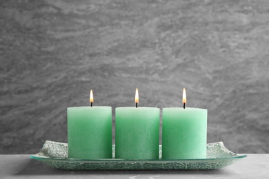 Composition with three burning candles on table. Space for text