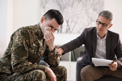 Professional psychotherapist working with military man in office