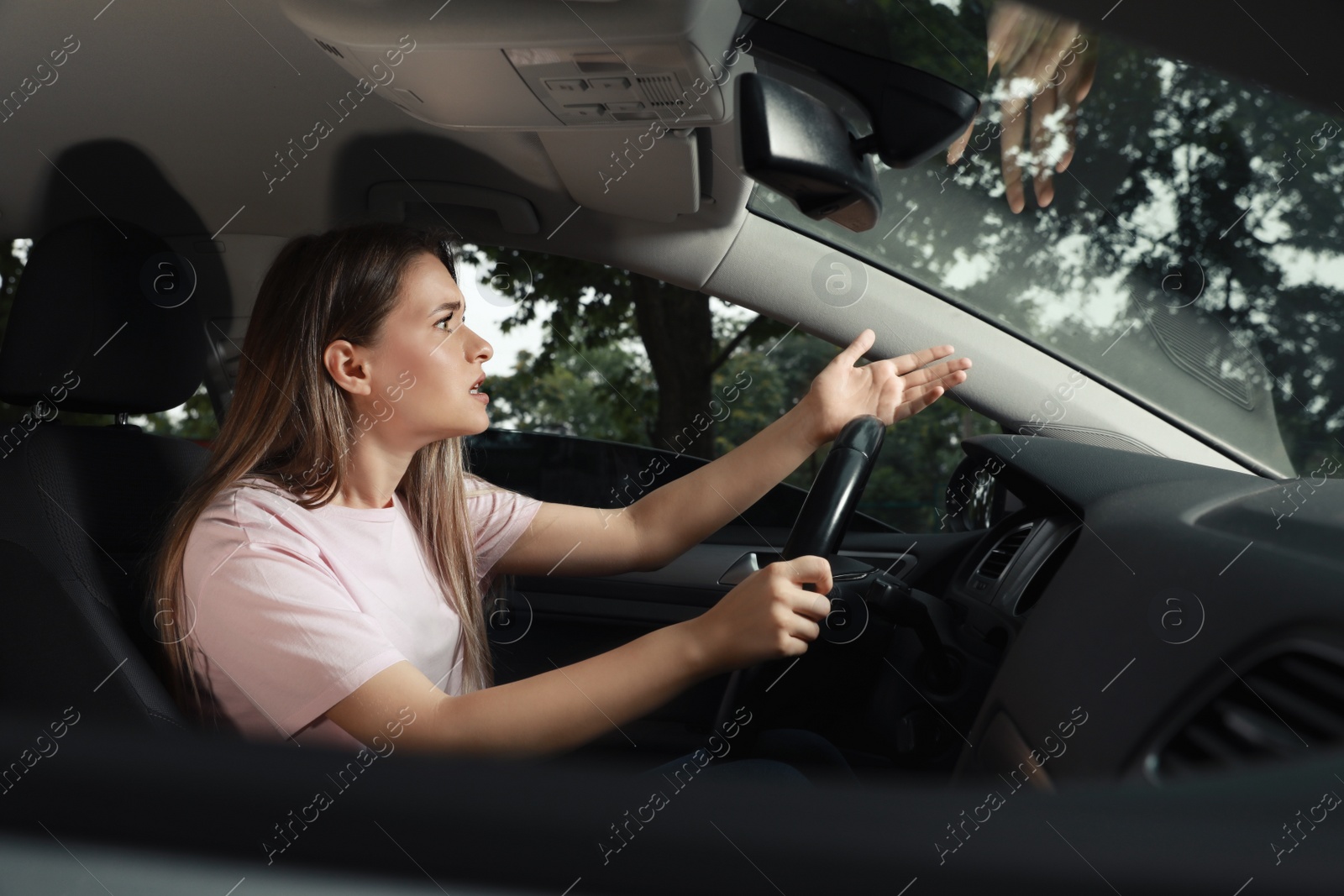 Photo of Stressed young woman in driver's seat of modern car