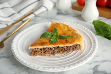 Piece of delicious pie with minced meat on white marble table