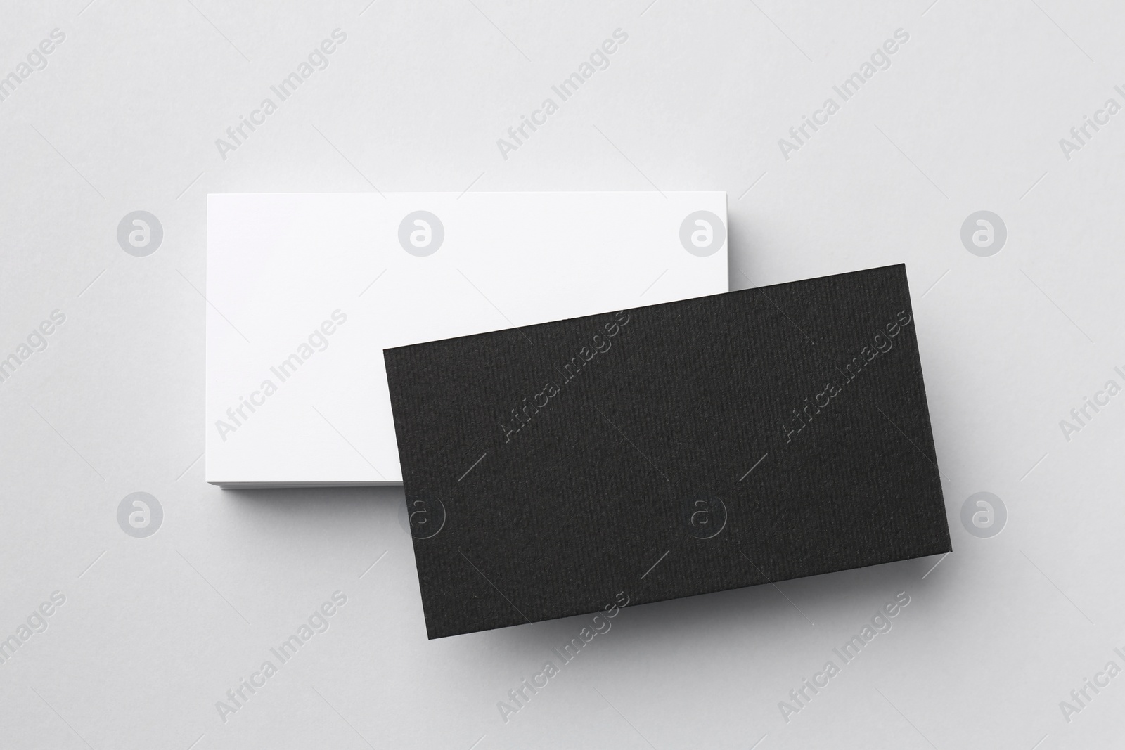 Photo of Blank black and white business cards on light background, top view. Mockup for design