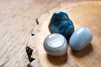 Beautiful blue angelite, grey agate and shattuckite gemstones on wooden stand, closeup