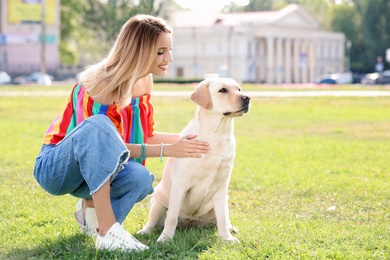 Photo of Cute yellow labrador retriever with owner outdoors
