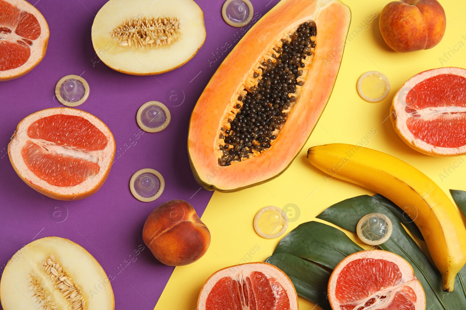 Photo of Flat lay composition with condoms and exotic fruits on color background. Erotic concept