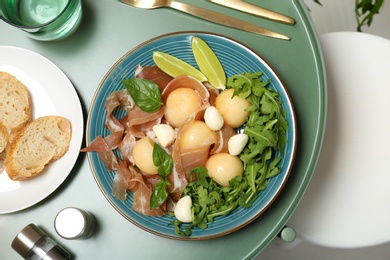 Photo of Flat lay composition with melon and prosciutto appetizer served on table