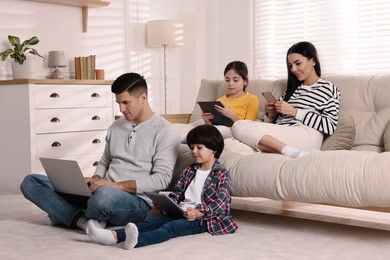 Internet addiction. Family with different gadgets in living room