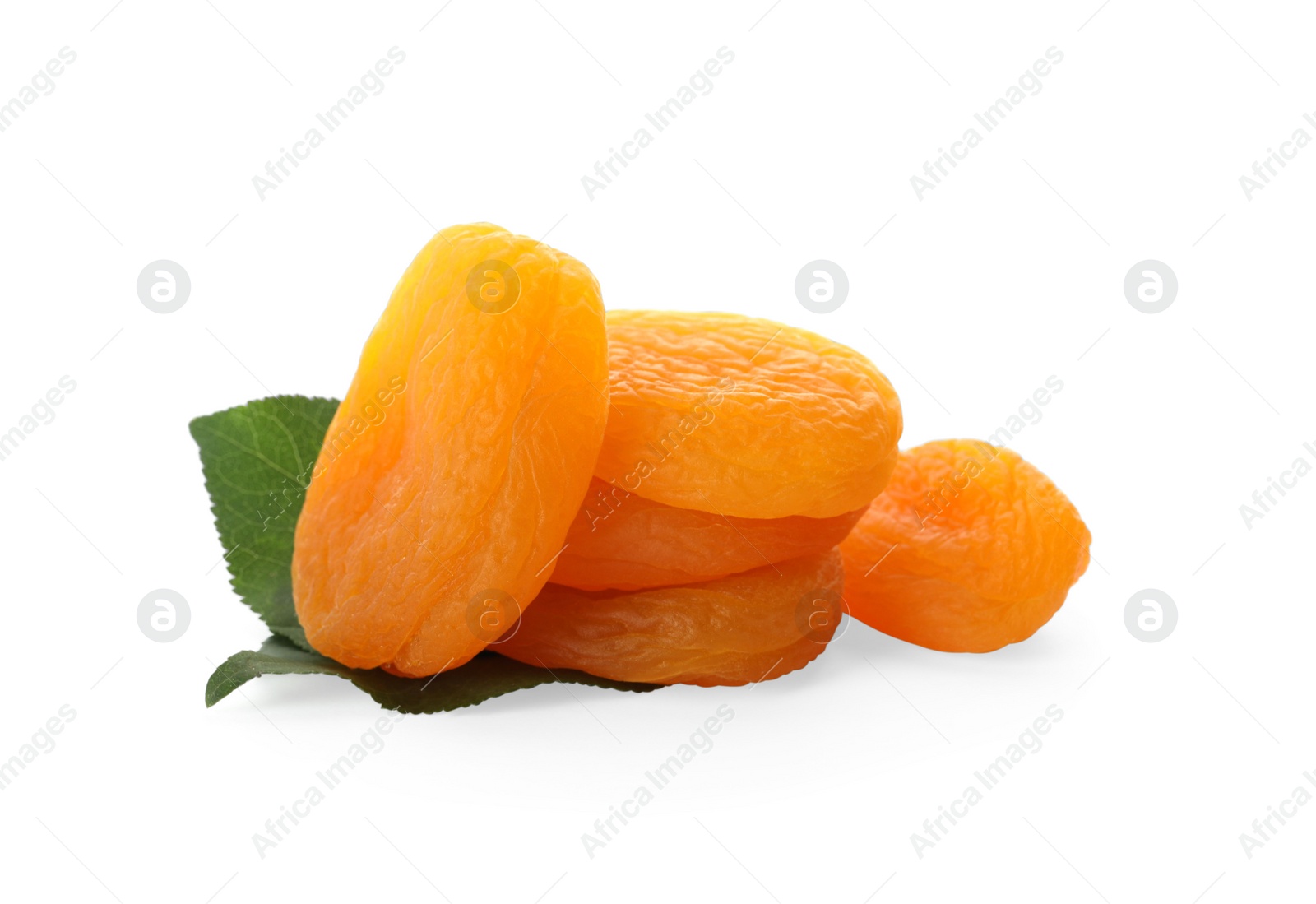 Photo of Pile of tasty dried apricots with leaves on white background