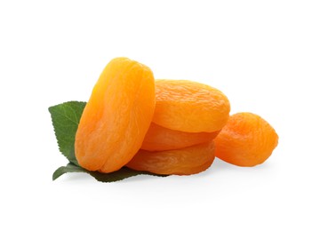 Photo of Pile of tasty dried apricots with leaves on white background