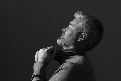 Photo of Portrait of handsome man on dark background. Black and white effect