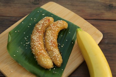 Photo of Delicious fresh and fried bananas on wooden table, closeup