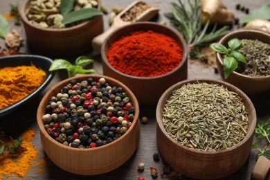 Photo of Different herbs and spices on wooden table, closeup