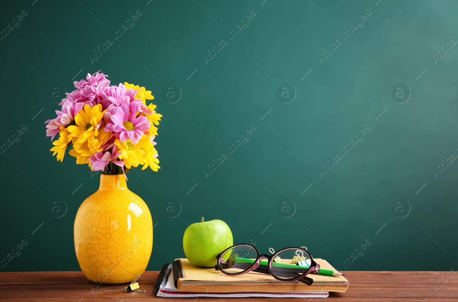 Photo of Bouquet of flowers and notebooks with eyeglasses on table. Teacher day celebration