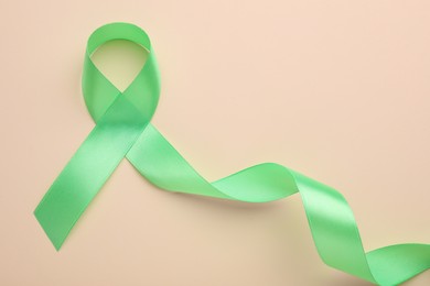 World Mental Health Day. Green ribbon on color background, top view