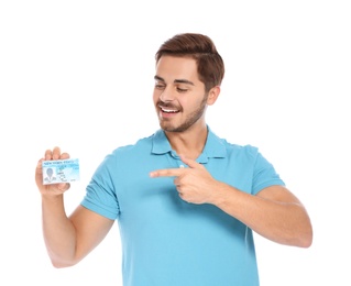 Happy young man with driving license on white background