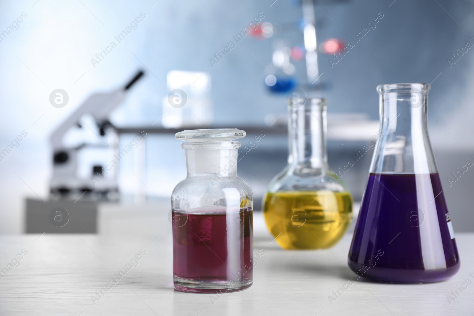 Photo of Laboratory glassware with samples on table indoors, space for text. Solution chemistry