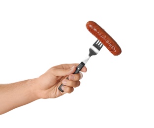 Photo of Man holding fork with grilled sausage on white background, closeup. Barbecue food