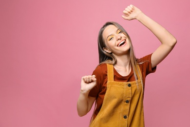 Photo of Happy teenage girl on pink background. Space for text