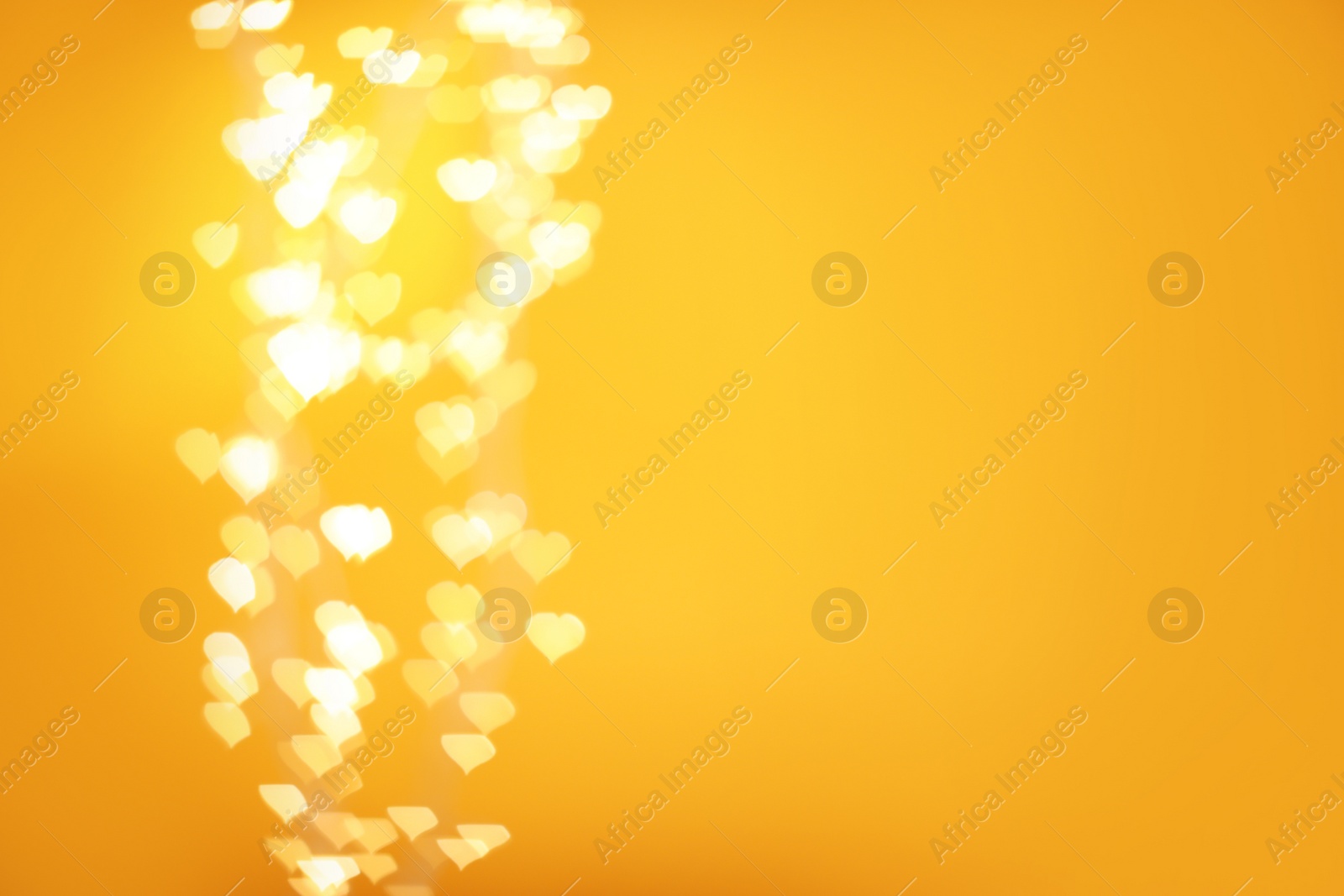 Photo of Blurred view of beautiful lights on yellow background, space for text. Bokeh effect