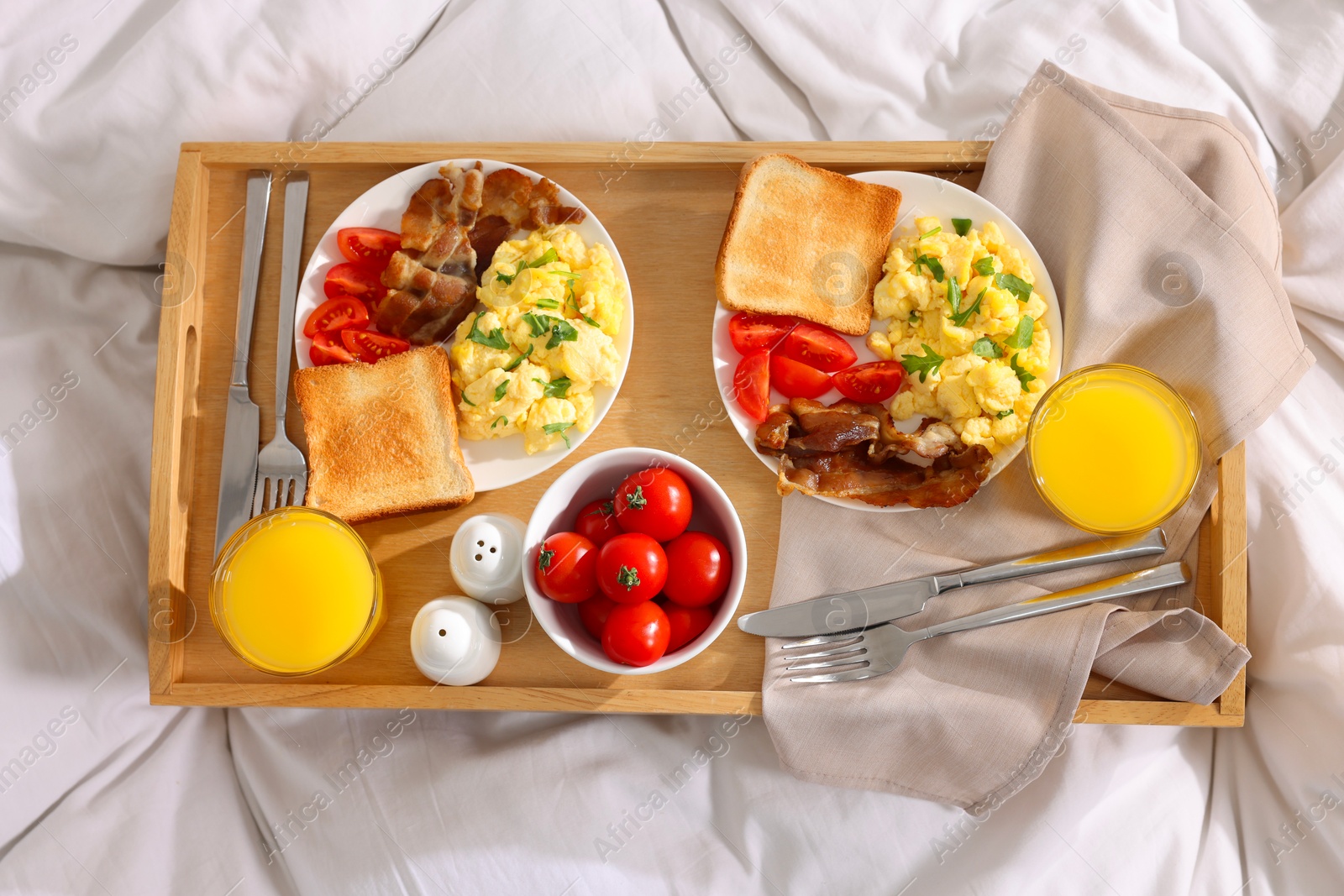 Good morning. Tray with tasty breakfast on bed, top view Photo of Good morning. Tray with tasty breakfast on bed, top view
