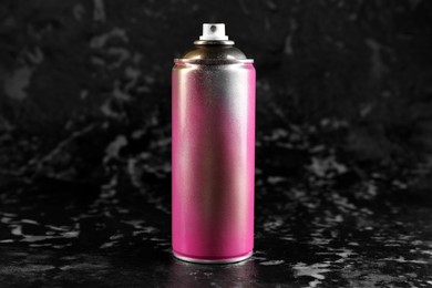 Photo of Used can of spray paint on black marble background