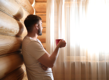 Photo of Man with drink near window indoors. Lazy morning