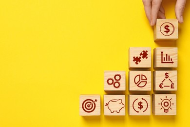 Image of Top view of woman and wooden cubes with different images on yellow background. Space for text