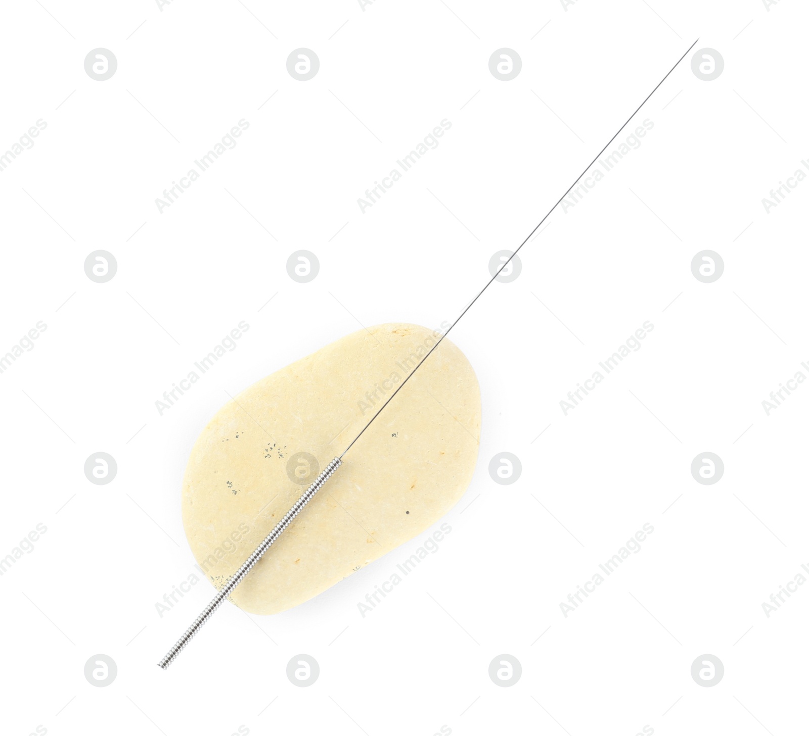 Photo of One needle for acupuncture and stone on white background, top view