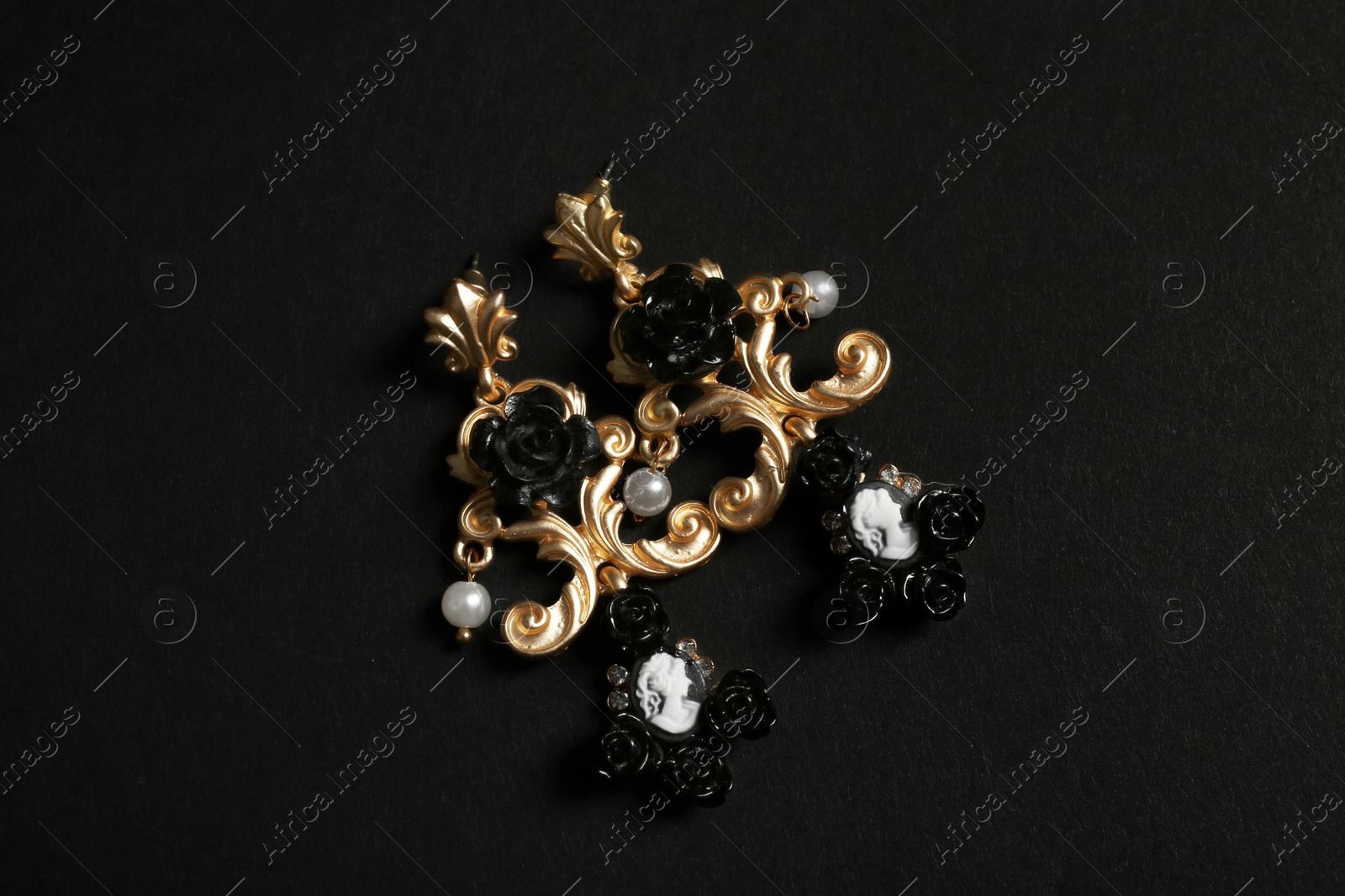 Photo of Beautiful earrings on black background. Luxury jewelry