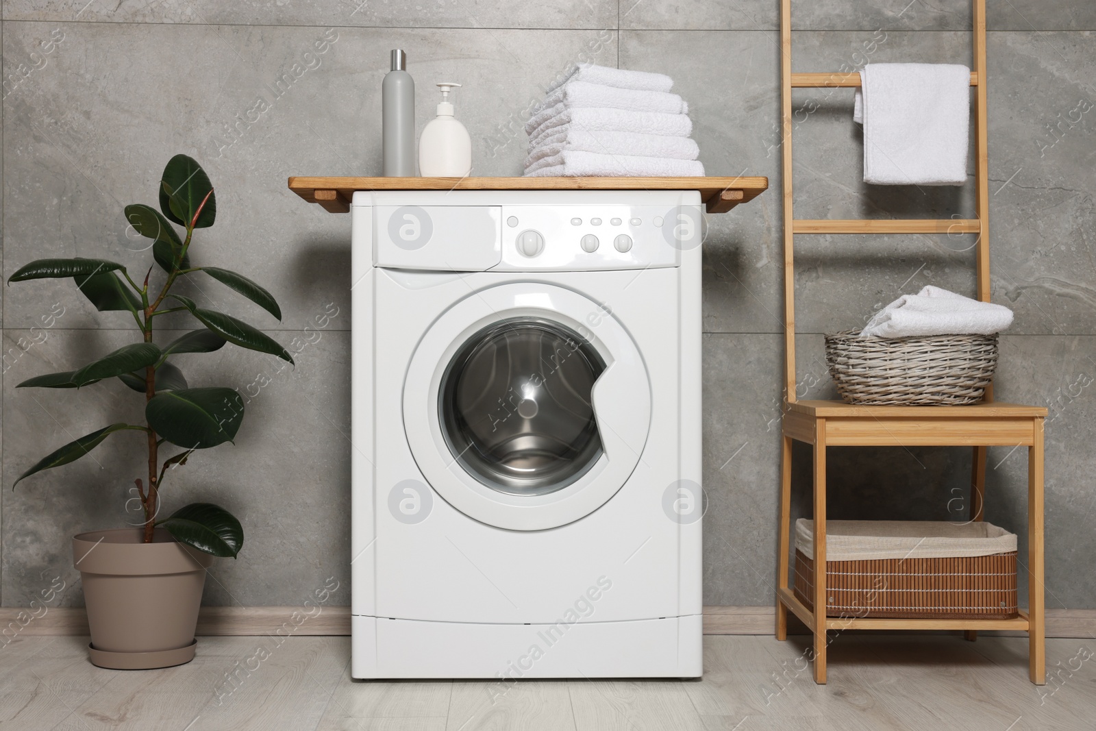 Photo of Stylish laundry room with modern washing machine. Interior design