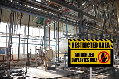 Sign with text Restricted Area Authorized Employees Only near different equipment indoors