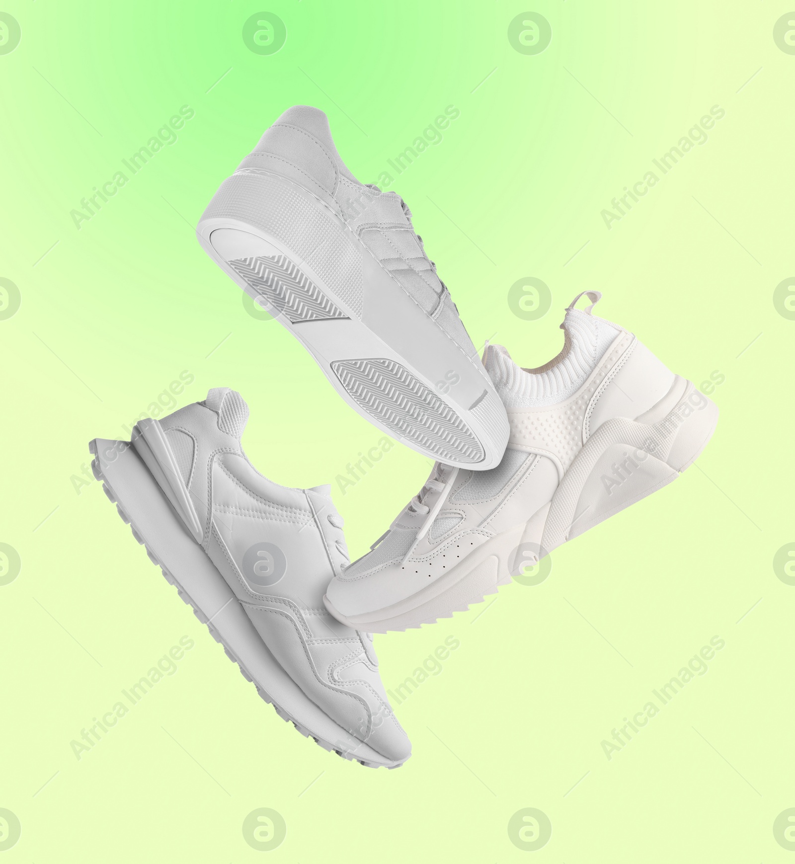 Image of Different sneakers falling on green gradient background
