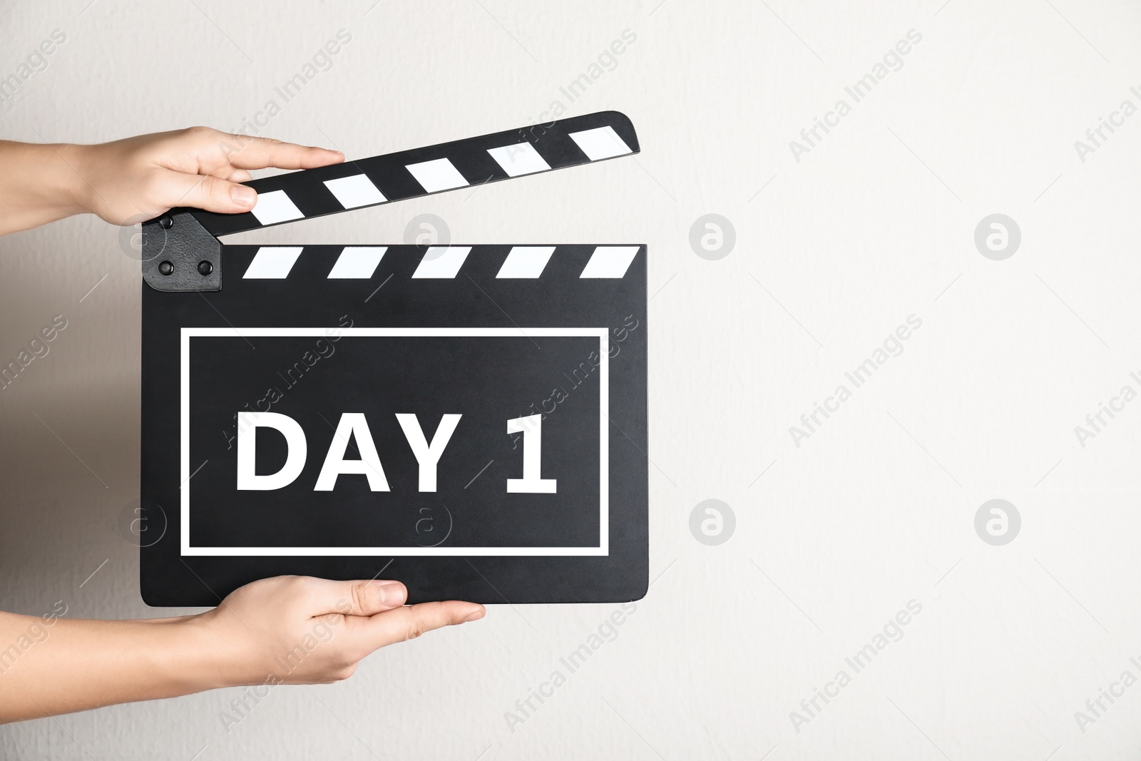 Image of Starting new life chapter. Woman holding clapperboard with text Day 1, closeup