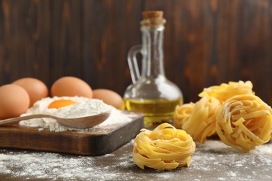 Photo of Raw noodles and ingredients on wooden table, space for text