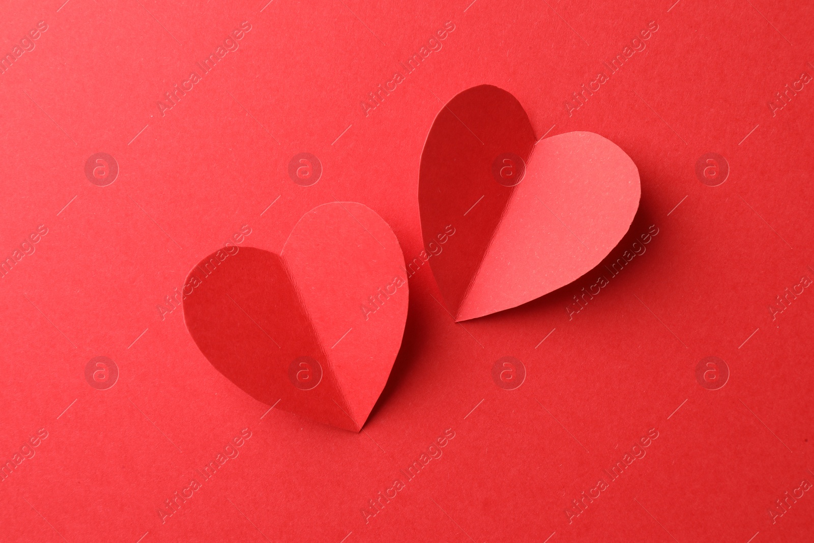 Photo of Paper hearts on red background, flat lay