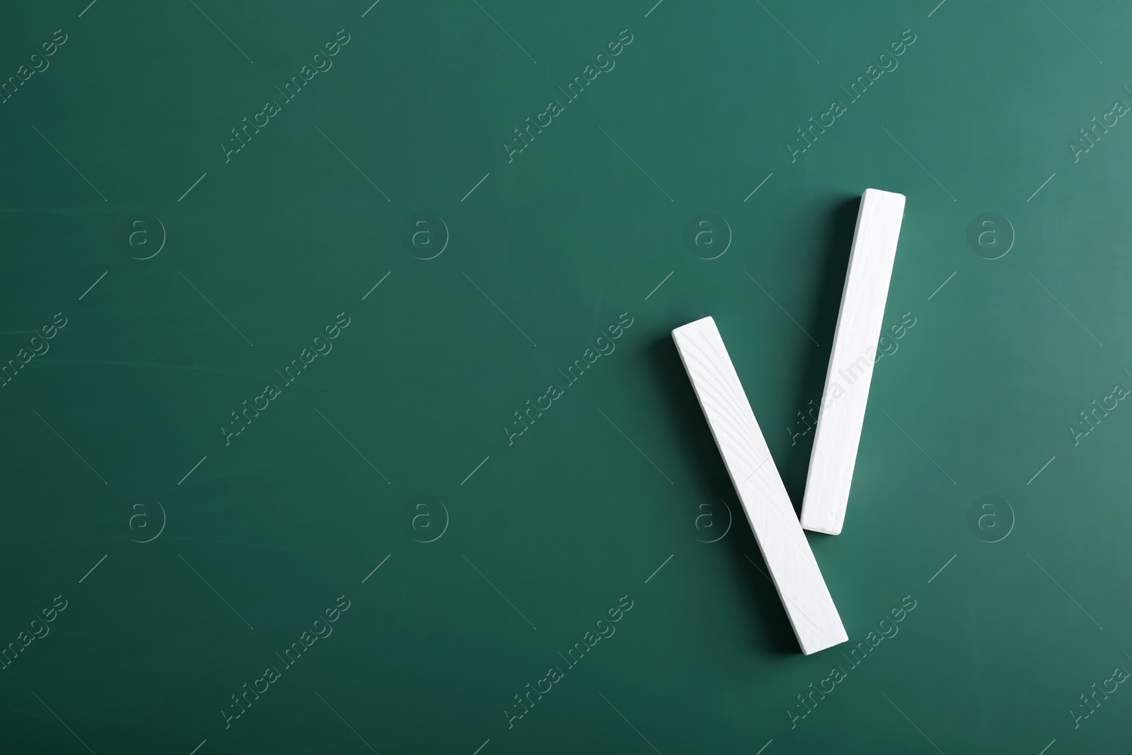 Photo of Pieces of chalk on green background, top view