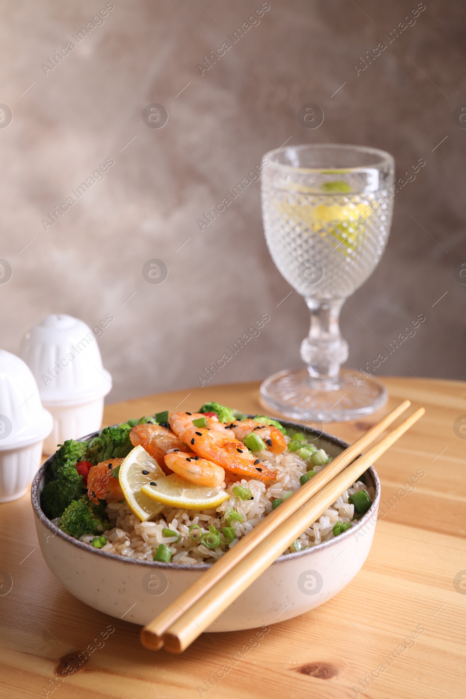 Photo of Tasty rice with shrimps and vegetables served on wooden table